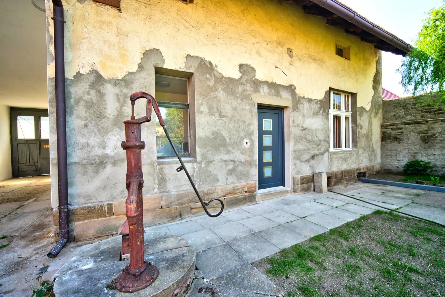 Dvorní fasáda s historickou litinovou pumpou